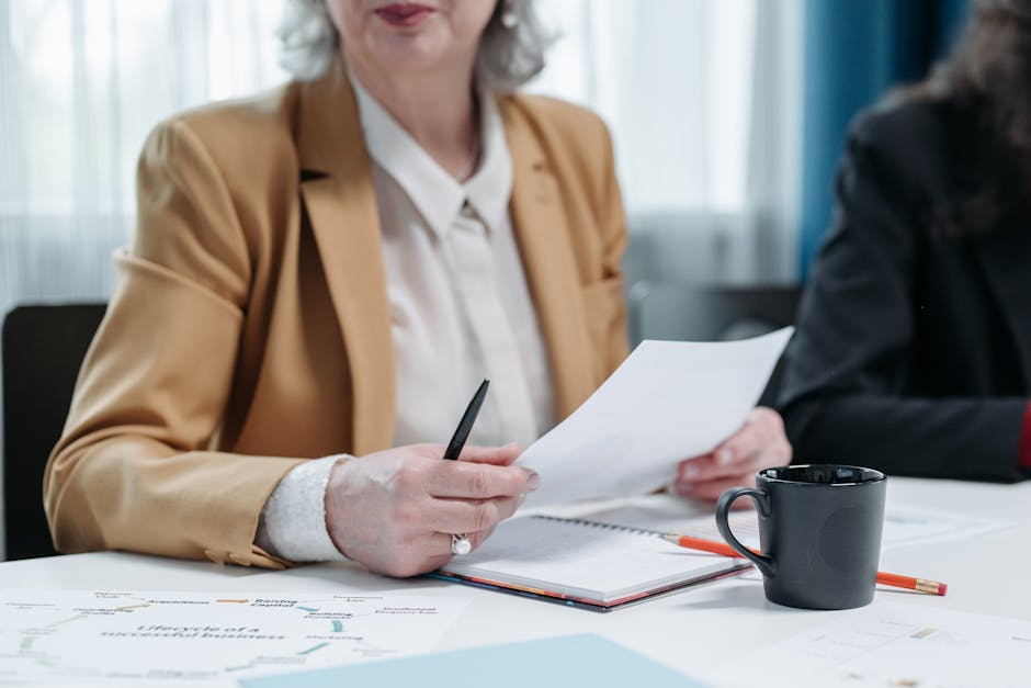 A senior woman reviews documents at a business meeting, highlighting professionalism.